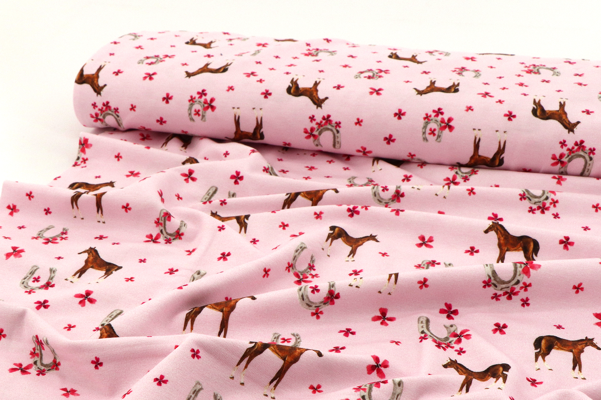 Jersey di cotone, piccoli cavalli e ferri di cavallo su rosa